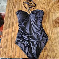 Front view of black one-piece swimsuit with MK logo hardware