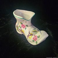 Right side view of porcelain boot vase showing floral and bird design