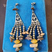 Front view of both earrings on blue background