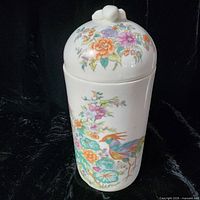 Front view showing floral and bird motif and lid design