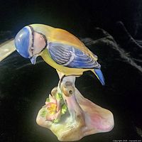 Front view of multicolor Blue Tit figurine on flowering branch