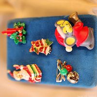 All five brooches pinned to blue display, showing designs and scale