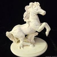 Front left view of off-white resin horse figurine on oval base