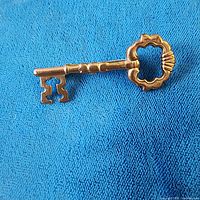 Front view of gold-tone skeleton key brooch