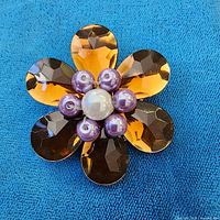 Front view showing amber petals and pearl cluster