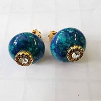 front view showing blue-green domed earrings with rhinestones