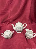 Covered sugar bowl, creamer and additional teapot visible