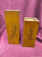 Front view of both candle holders showing height difference and carved pattern