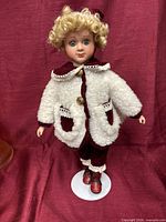 Full view of doll on stand showing outfit and boots