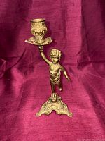 Front view of brass cherub candlestick holder