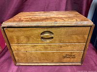 Front view of wooden bread box showing carved pulls and "Pain Bread" text