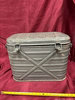 Front view of gray ribbed metal Mermite container with lid closed showing latches and handles