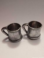 Pair of Childs miniature metal mugs side by side
