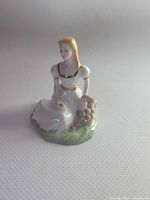 Front view of porcelain woman figurine with basket of flowers