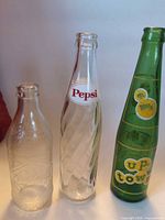 Front view showing three distinct glass soda bottles with branding and shapes