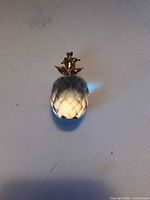 Full view of faceted crystal ornament showing gold-tone leaf top