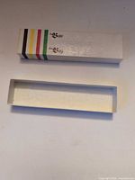 Box lid with La Baie / The Bay logo and stripes beside empty base