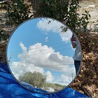 Front view showing round mirror, silver frame, reflective surface