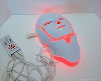 Mask illuminated red, connected to controller and cables