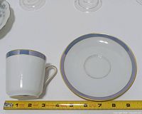 Pastel band cup with matching saucer next to ruler