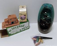 Group shot of ceramic waterfall burner, terracotta holder with box, cone box, bag of cones