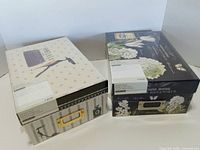 Two sealed photo boxes side by side showing designs and sealed packaging