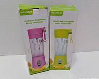 Front of two boxed NO.iHM-03 portable rechargeable blenders showing colors and packaging.