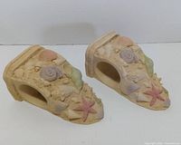 Top and side view of both resin wall shelves showing seashell motif