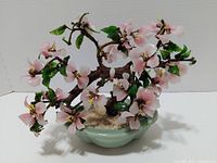 Front view of Peking glass bonsai tree with pink flowers in green pot