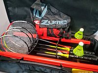 Open carrying case showing four rackets, poles, net bag and two shuttlecocks