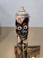 Front view showing graffiti face artwork on spray can