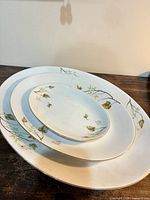 Three stacked oval platters showing size gradation and pattern