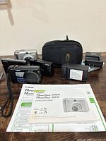 Group shot of all cameras, chargers, case and manual