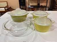 All four casseroles, three green with lids and one clear without lid