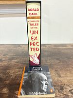 Spine view of hardcover Complete Tales of the Unexpected standing beside paperback