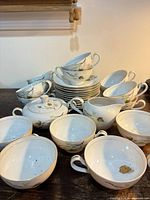 Full lot showing multiple cups, saucers, sugar bowl and creamer