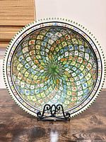 Front view of hand-painted ceramic platter on metal stand