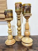 Front view showing all three wooden candle holders with candles