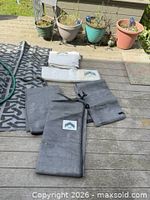 Five folded canopy side panels, grey mesh and white solid, on deck