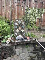 Front view of fountain with mosaic tile backplate, copper outlet, basin, hose and garden gnome