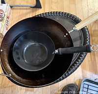 Two woks nested, showing size difference and handles