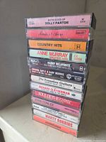 Stack of 13 cassette tapes showing titles and cases