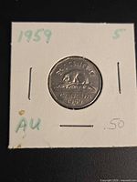 Coin in 2x2 cardboard flip showing year, denomination, grade marking