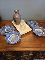 Group view showing brass vase, glass decanter, tray, and blue & white dishes