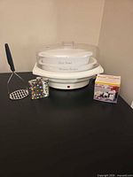 Group shot showing all four items: steamer, flask, masher, garlic gadget box