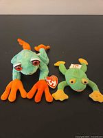 Front view of both Ty frog plush toys showing colours, size difference, and tags