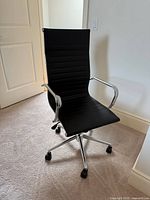 Front angled view of chair showing upholstery, chrome arms and base