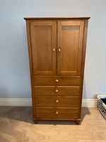 Front view of Ethan Allen armoire showing doors and drawers