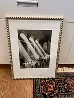 Framed black-and-white Grand Central Station print leaning against cabinet