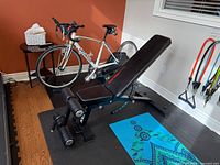 Full view of Keppi adjustable bench in inclined position on gym mat